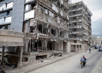 An Iranian motorcyclist rides past the Gandhi Hospital, which is damaged after US-Israeli strikes on a state TV telecommunication tower nearby in Tehran, Iran, on March 2, 2026.